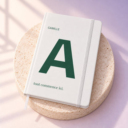 Simulation — carnet ARCONOT A5 blanc, couverture personnalisée en UV — fond ivoire/lavande et travertin