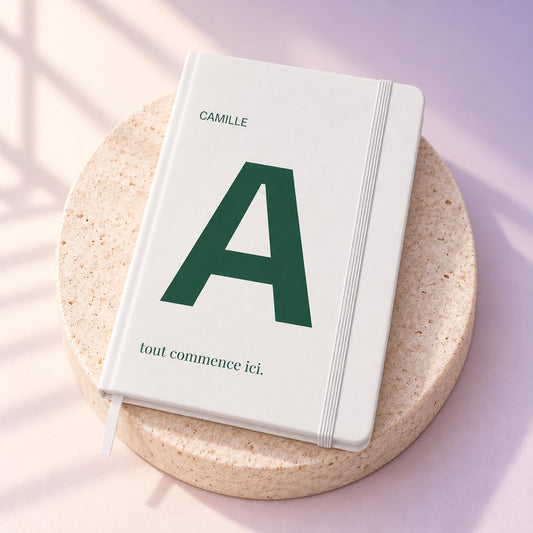 Simulation — carnet ARCONOT A5 blanc, couverture personnalisée en UV — fond ivoire/lavande et travertin