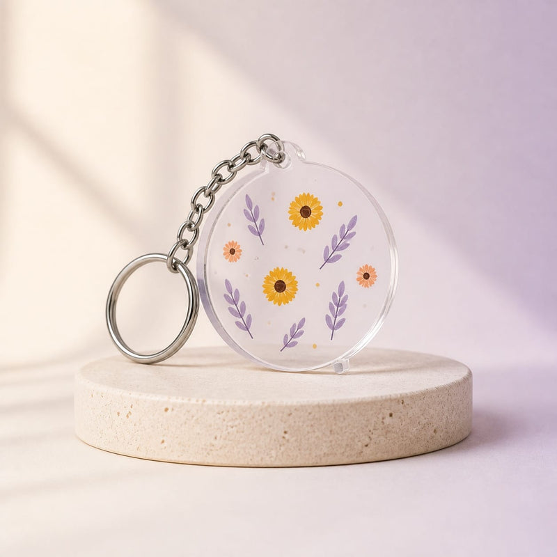 Porte-clé personnalisé transparent présenté sur un fond studio crème et lilas